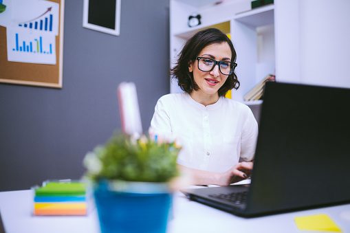 Brunette Woman In Eyeglasses Typing Report